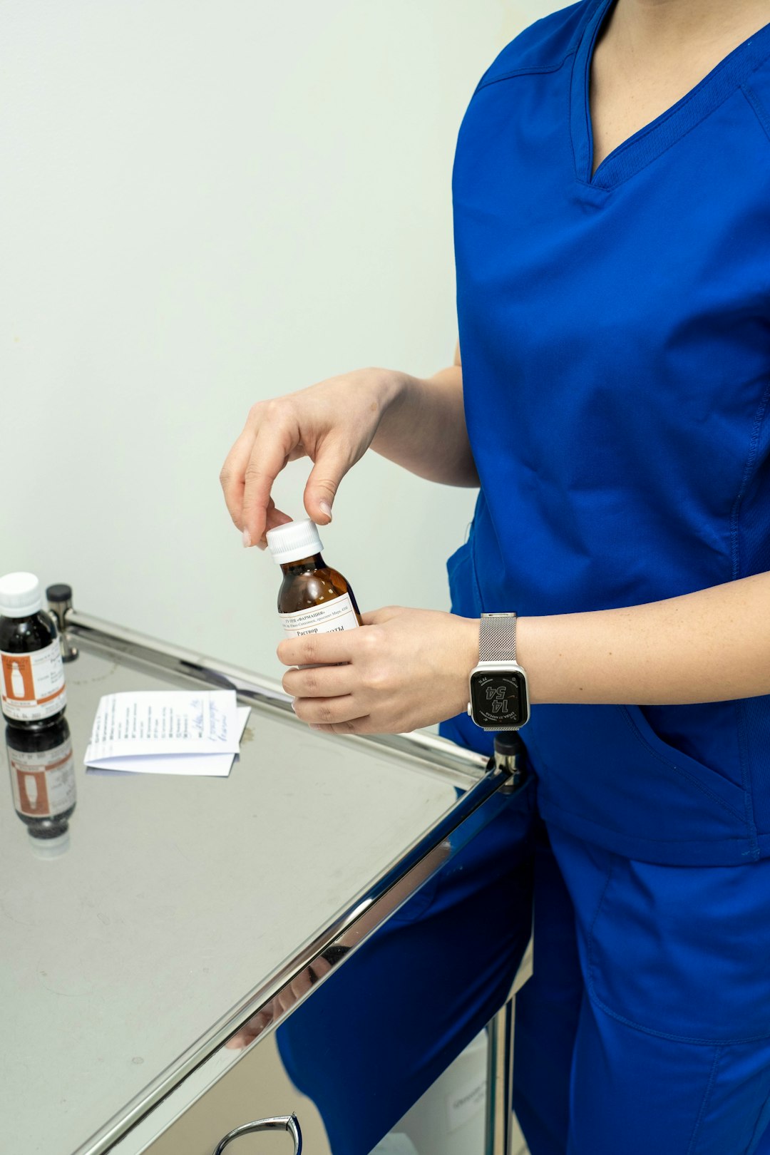 gallery-04 a-woman-in-a-blue-dress-holding-a-bottle-of-medicine-tc7e4np0njc